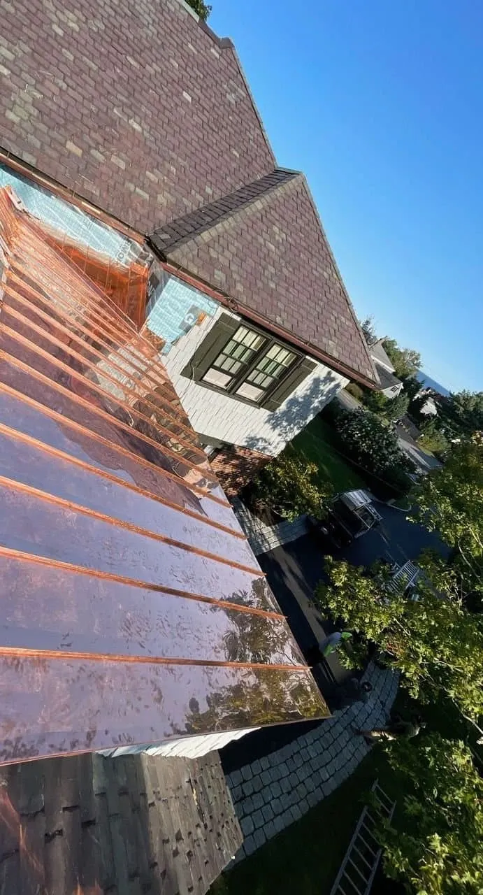 New standing seam copper roof installed by Art Slate below a slate roof on a Greater Boston home