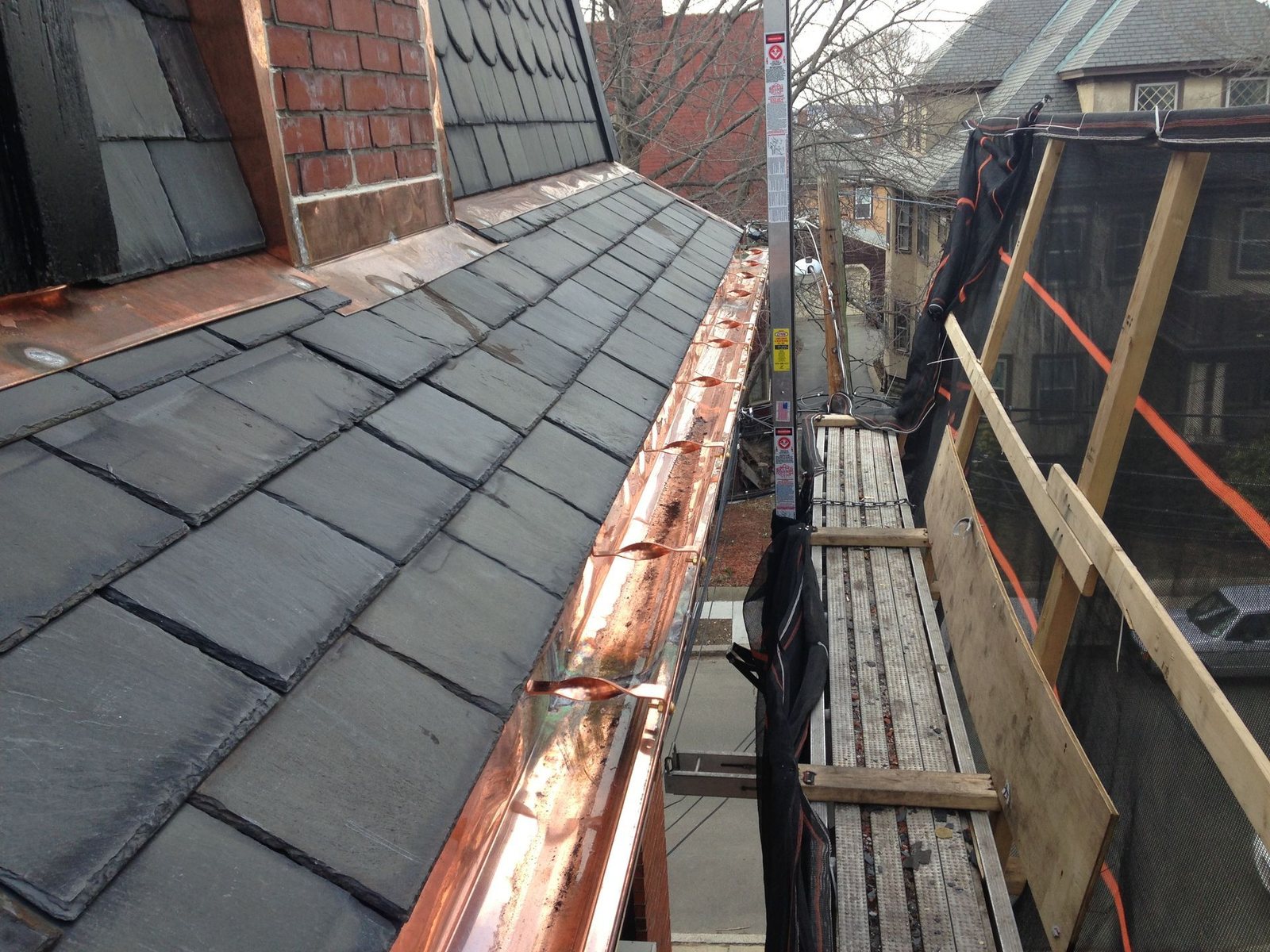 Detail of slate roof tiles and copper gutter